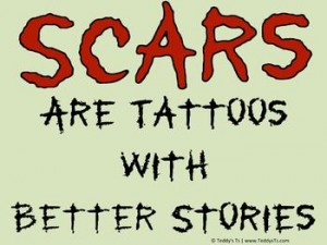 Stonewashed green shirt with dried blood red words: Scars are Tattoos with Better Stories.